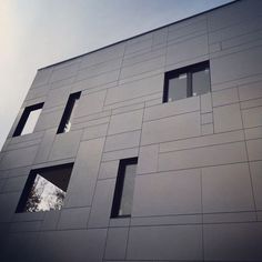 the side of a building that has several windows on each window and one in the middle