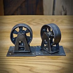 two metal wheels sitting on top of a wooden table