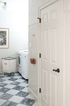 an open door leading to a washer and dryer in a room with white walls