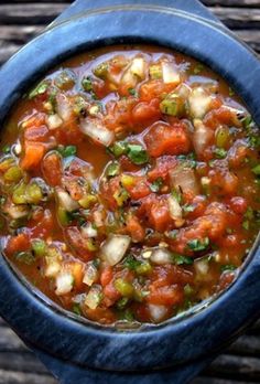 a blue bowl filled with soup and vegetables