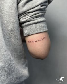 a person with a small tattoo on their arm that reads, and the words are written in