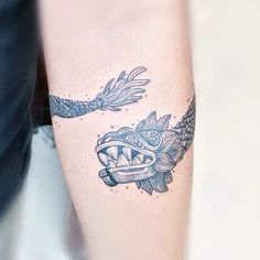 a tattoo on the arm of a woman with fish and dragon designs around her body