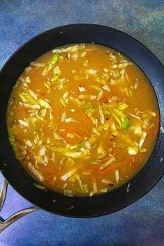 a bowl of soup with carrots, celery and other vegetables in it