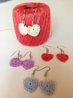 crochet heart earrings are displayed next to a ball of yarn