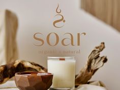 a candle and bowl sitting on a table next to a sign that says soar organic & natural