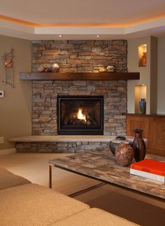 a living room filled with furniture and a fire place in the middle of the room