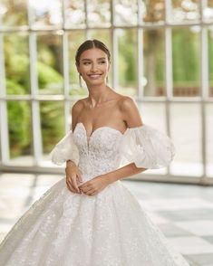 a woman in a wedding dress posing for the camera