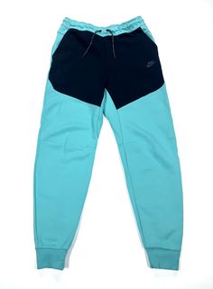 Elevate your activewear collection with these Nike Sportswear Tech Fleece Joggers Pants in a stylish washed teal and black color combination. The pants are designed with a drawstring closure, elastic waist, taped seams, and adjustable waist for a comfortable and breathable fit. The cotton blend material and fleece fabric type make it perfect for fall, winter, and spring seasons. These pants also come with easy care, zip pocket, pockets, and slim fit features that make it ideal for gym and traini Nike Tech Fleece Dark Blue, Nike Tech Hip Pack Green, Green Nike Joggers With Pockets, Blue Technical Sports Bottoms, Blue Fleece Sweatpants Sportswear, Nike Sportswear Tech Fleece, Black Color Combination, Joggers Pants, Tall Men