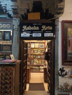 the entrance to an art gallery with many paintings on the walls and in the doorway, there is a sign that says fabola arts