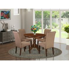 a dining room table with four chairs and a rug on the floor in front of it