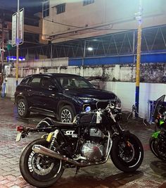 two motorcycles parked next to each other in front of a black car and another motorcycle