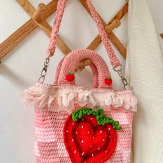 a crocheted strawberry purse hanging on a wall