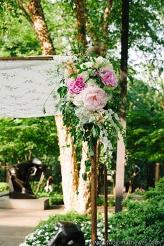 an outdoor ceremony with flowers and greenery