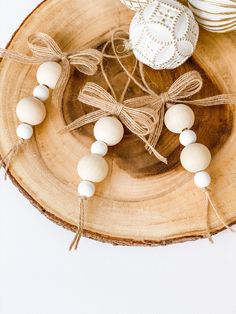 some white beads are sitting on a wooden plate with twine and lace around them