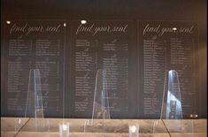 candles are placed on the side of a table with seating chart behind them and an illuminated candle holder in front of it