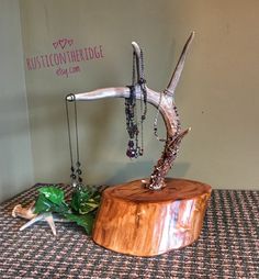 a wooden table topped with a necklace holder