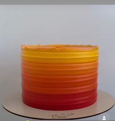 an orange and yellow cake is sitting on a plate