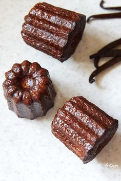 three pieces of brownie sitting on top of a table next to some chocolate sticks