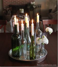 several wine bottles and candles on a tray