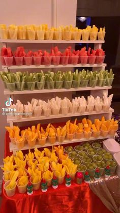 several trays filled with different types of food on display in front of a red table cloth