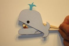 someone is cutting out a paper whale with scissors