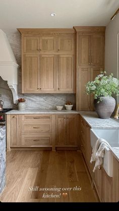 a kitchen filled with lots of wooden cabinets and counter top space next to a sink