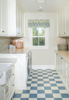 a white and blue checkered floor in a kitchen with an oven, sink, dishwasher and window