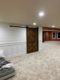 an empty living room with sliding doors and carpeted flooring in the basement area