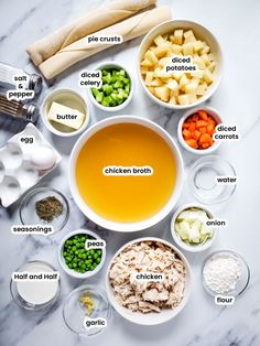 ingredients for chicken broth laid out in bowls on a marble counter top with the words chicken broth above them