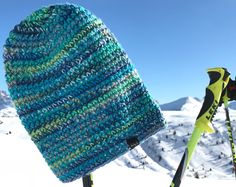 a knitted hat sitting on top of skis in the snow