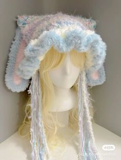 a white mannequin head wearing a blue and pink hat