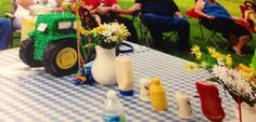 a group of people sitting around a table with vases and flowers on top of it