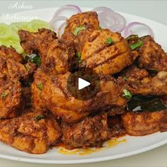 a white plate topped with chicken wings and garnished with green onions next to lettuce