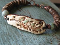 a close up of a bracelet on a table with beads and wood bead closures