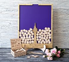 the cork art is displayed in front of a purple background with flowers and two small boxes