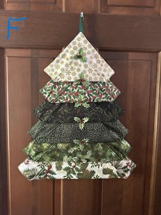 a christmas tree made out of fabric hanging on a door