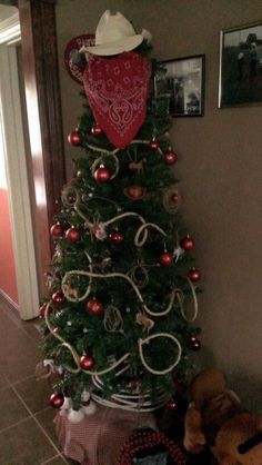 a small christmas tree decorated with red and white ornaments is next to a teddy bear