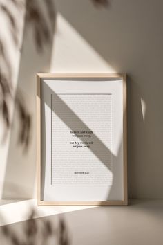 an open book sitting on top of a table next to a shadow from the window