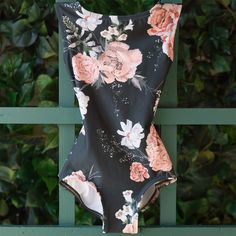 a bathing suit hanging on a fence with flowers all over it's back and sides