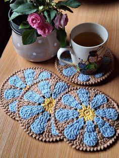 two crocheted coasters and a cup of coffee on a table