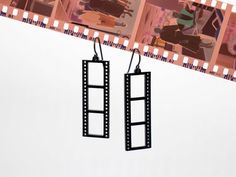 pair of black metal earrings with film strips hanging from them