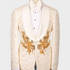 a white tuxedo with gold sequins and flowers on the lapel