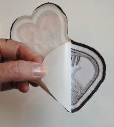 someone is holding an ornament in the shape of a heart