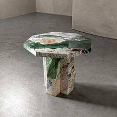 a table made out of marble in a room with concrete walls and flooring on the ground