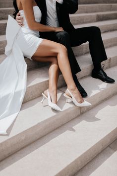 a man and woman sitting on some steps