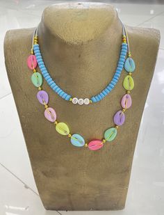 a necklace with multicolored beads is displayed on a mannequin