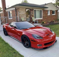 a red sports car parked in front of a house