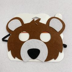 a brown bear mask on top of a white surface