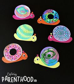 an image of colorful snails on black paper