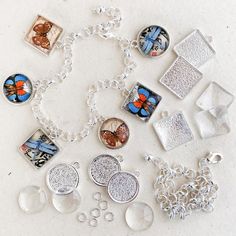 a bunch of different items that are on a white surface with silver chains and pendants